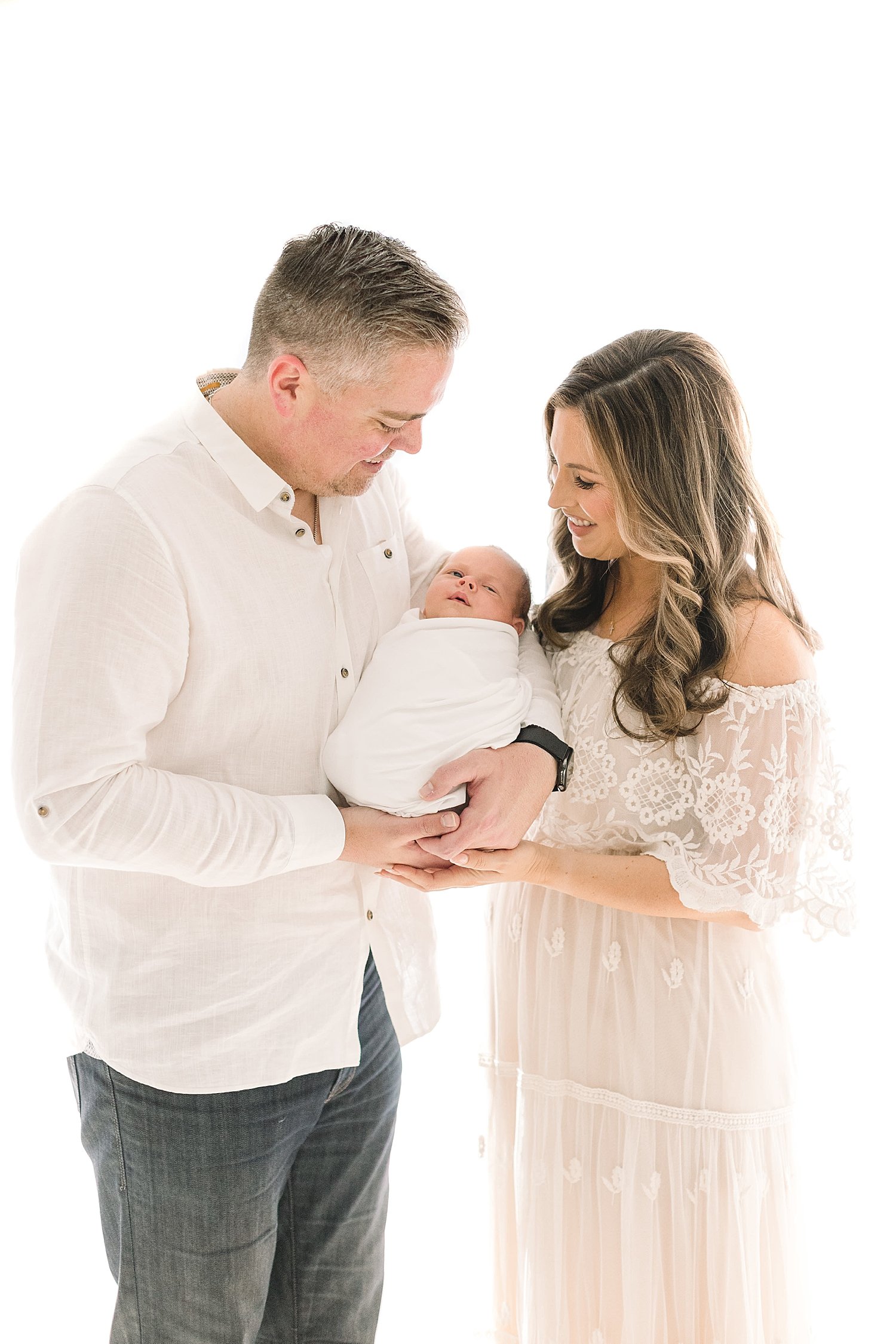 Mom and Dad holding their newborn son for portraits with Ambre Williams Photography in Orange County.