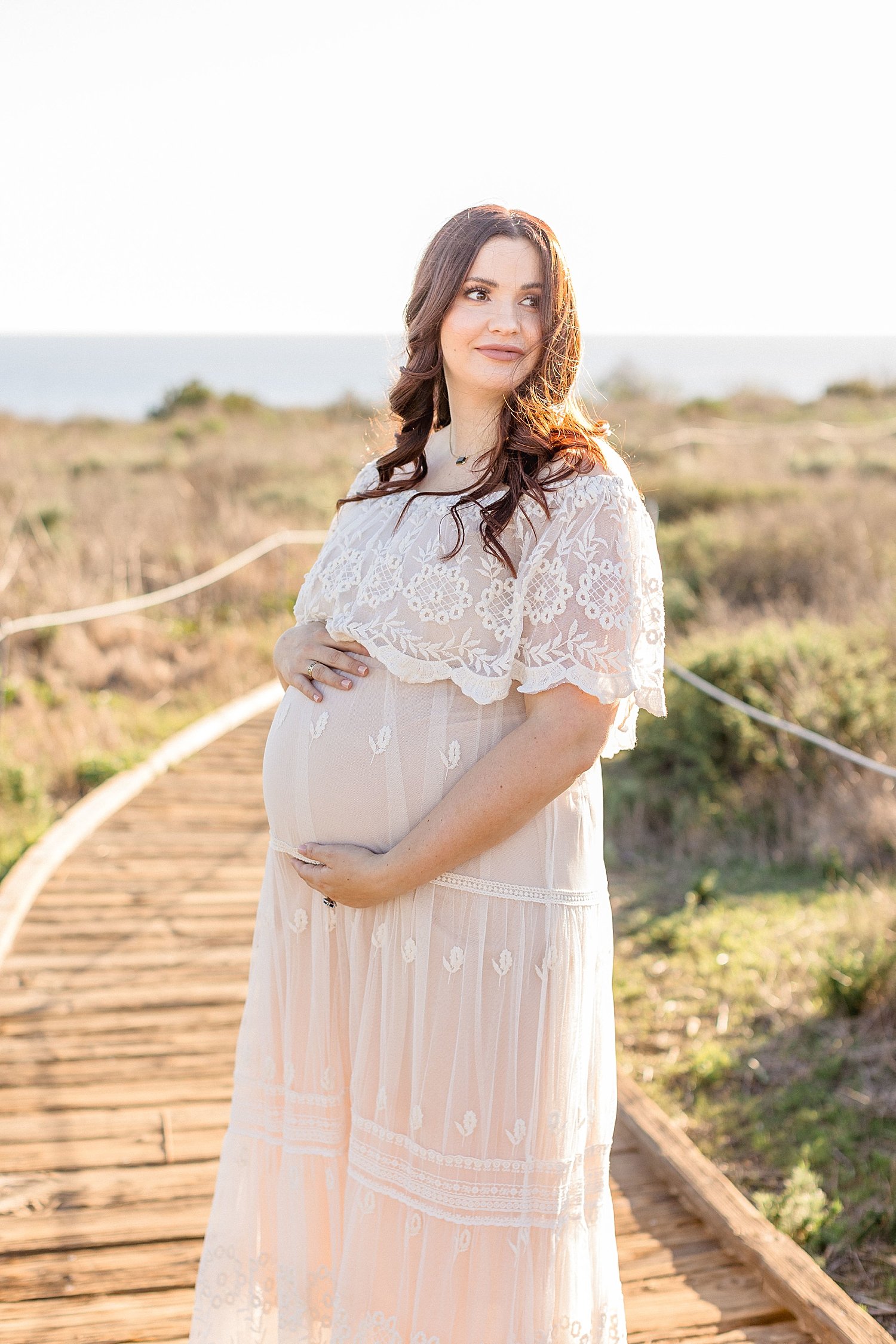 Pregnant mom wearing lace dress for photos with Ambre Williams Photography.