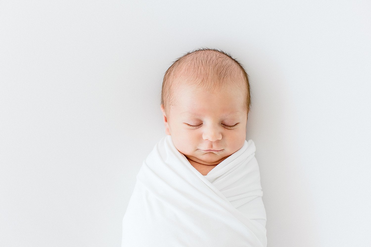 Newborn baby boy swaddled in white | Ambre Williams Photography