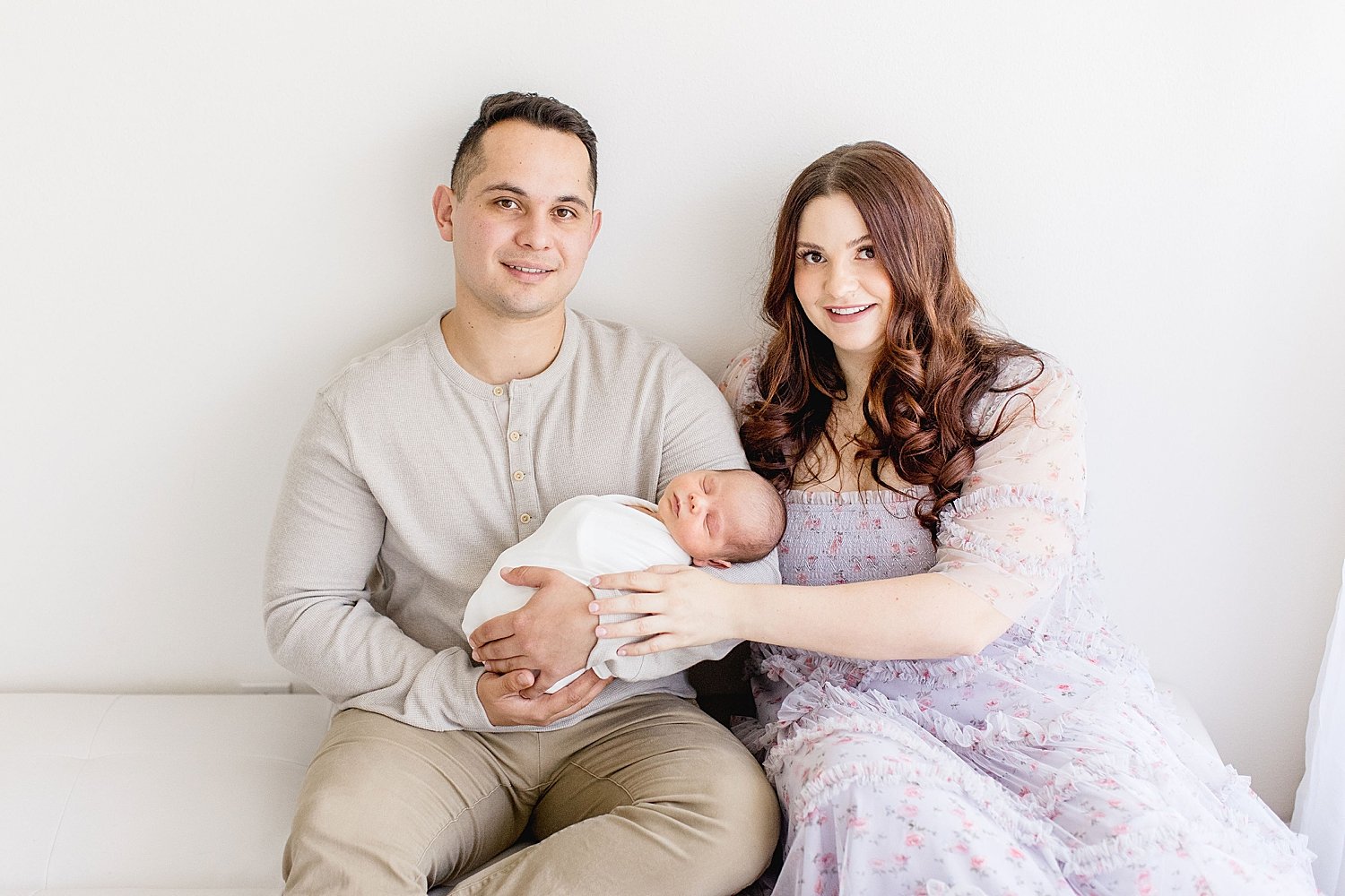 Mom and Dad with their precious newborn. Photo by Ambre Williams Photography.