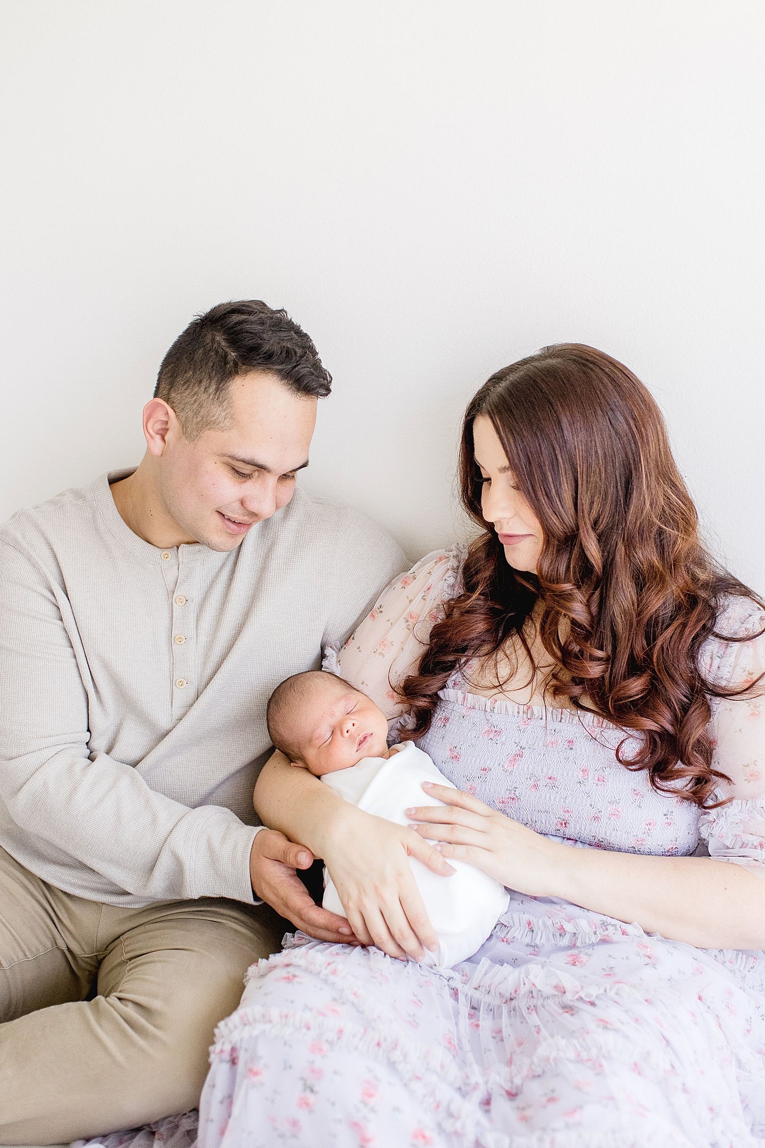 Mom and Dad with their precious newborn. Photo by Ambre Williams Photography.