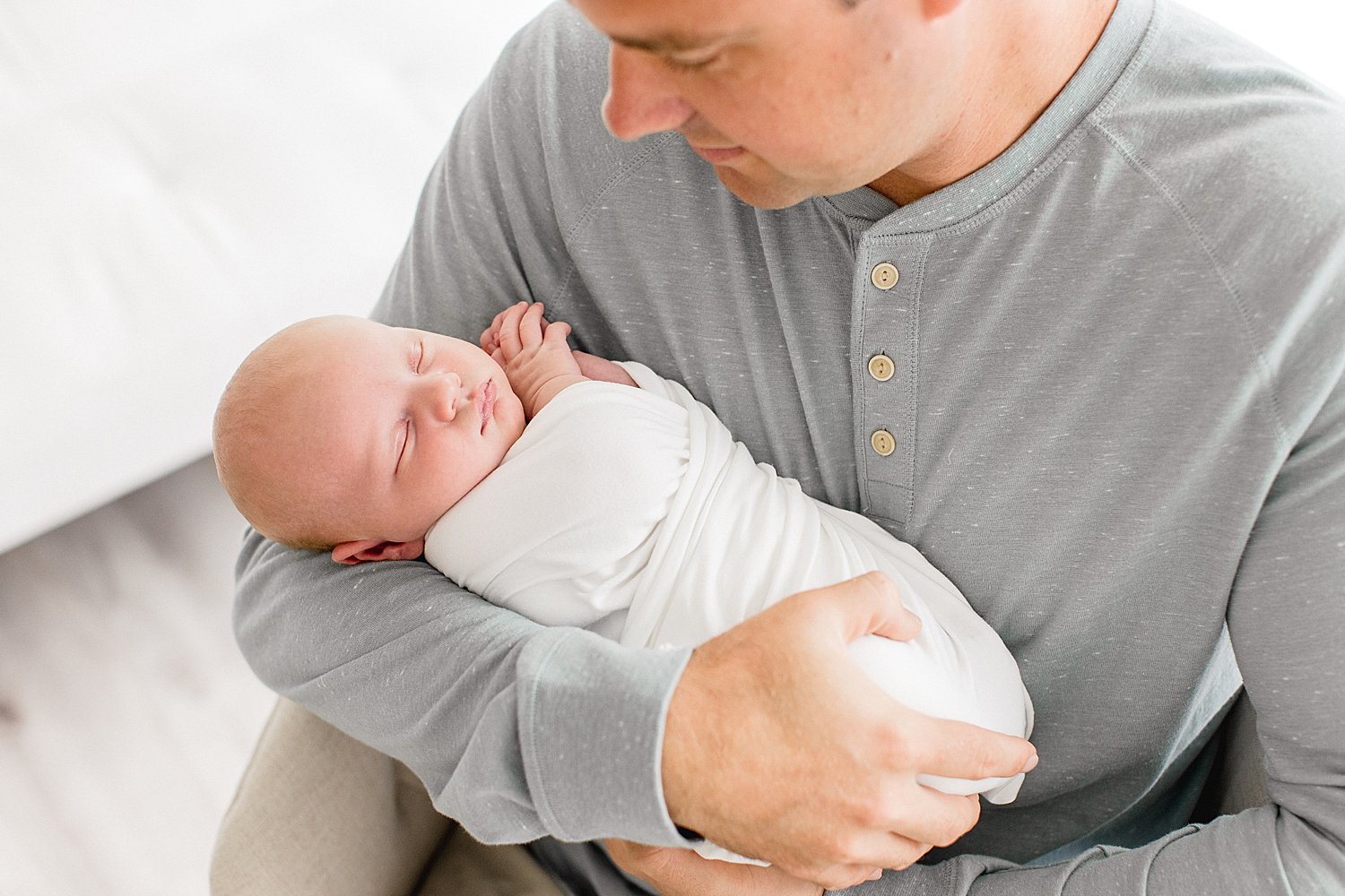 Dad holds newborn son in studio with Newport Beach photographer Ambre Williams Photography. 