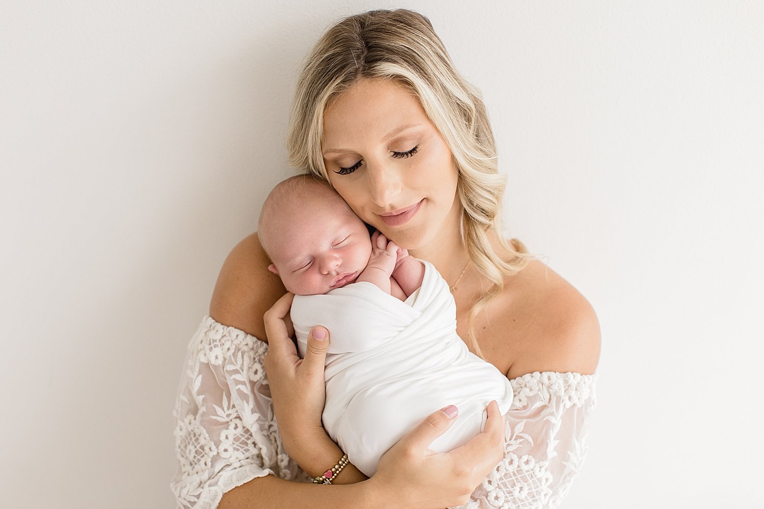 Mom holds newborn son in studio in Newport Beach with Ambre Williams Photography