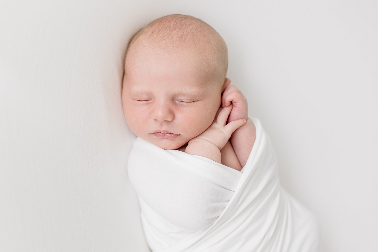 Baby boy in Newport Beach studio sleeping with hands | Ambre Williams Photography