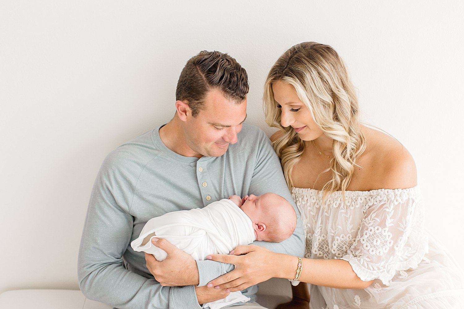 Parents looking down at newborn son | Ambre Williams Photography