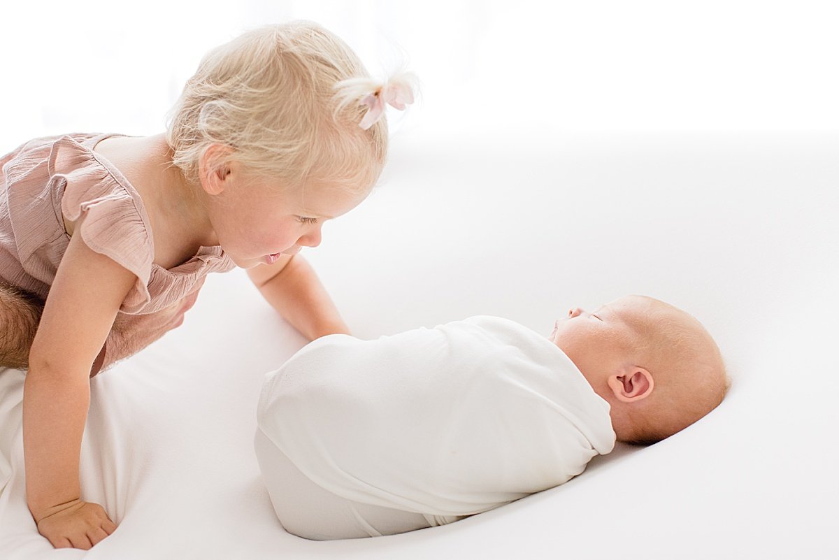 Snuggled Up Newborn with new Big Sister during Portrait Session with Ambre Williams Photography in Newport Beach