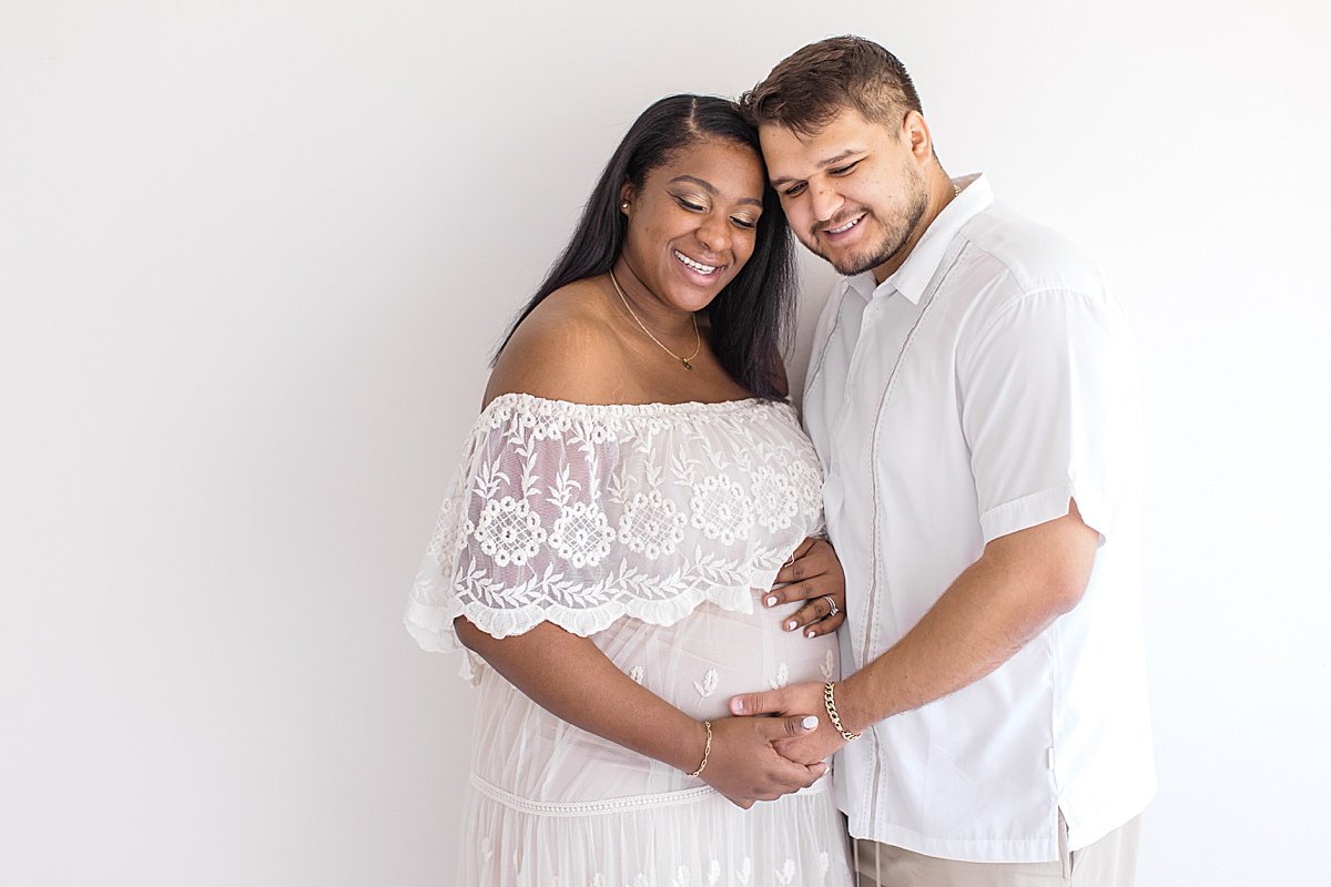 Husband and wife smiling together during maternity session with photographer Ambre Williams in Newport Beach