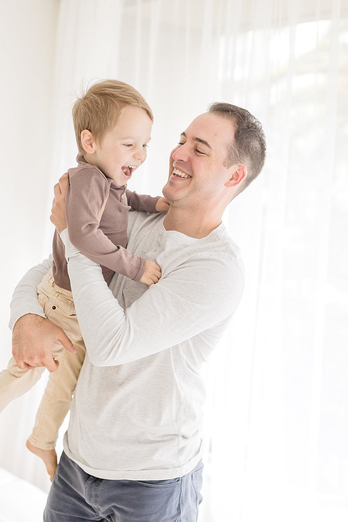 Dad and Son playing during family portrait session with Ambre WIlliams in Newport Beach