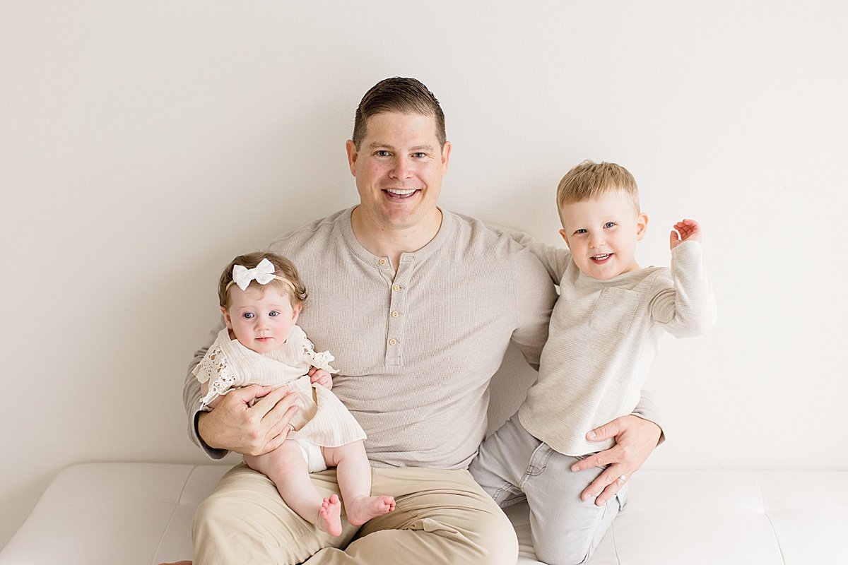 Dad sitting with his two children during Milestone Sitter Session with Ambre Williams Photography