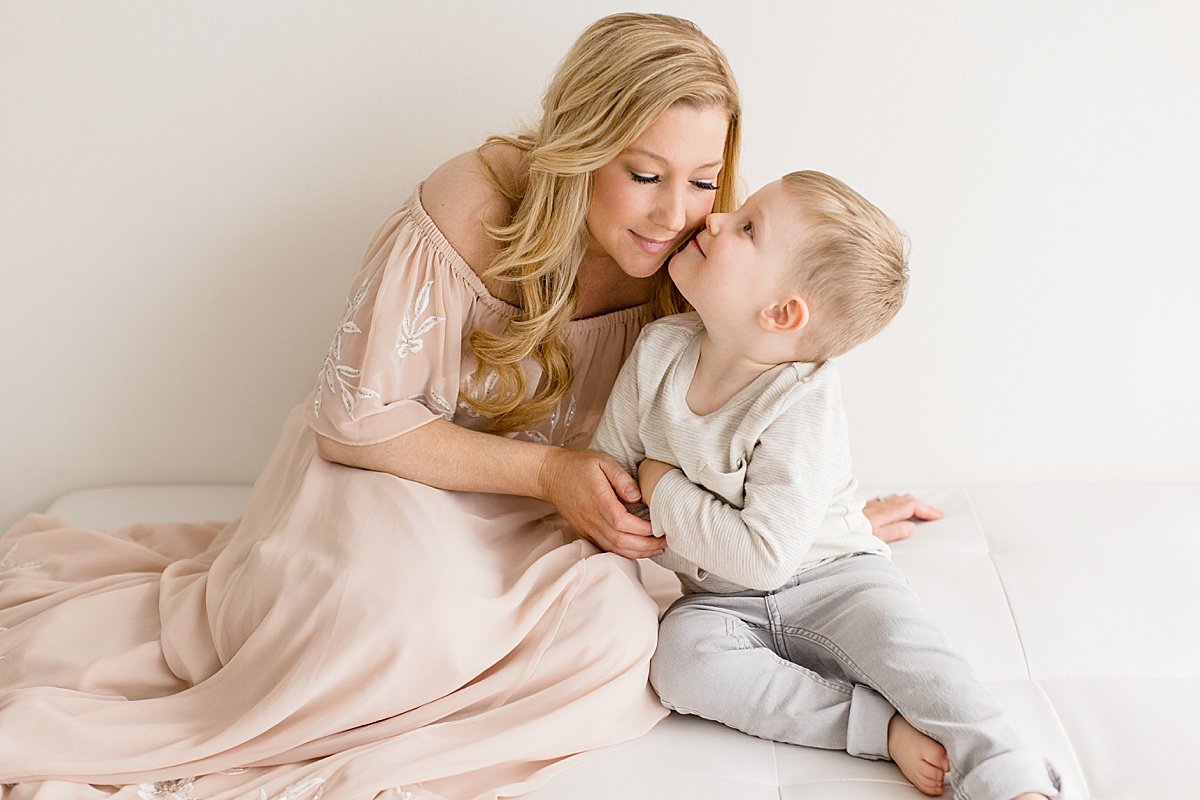 Son giving mom kisses during portrait session with Ambre WIlliams Photography in Newport Beach
