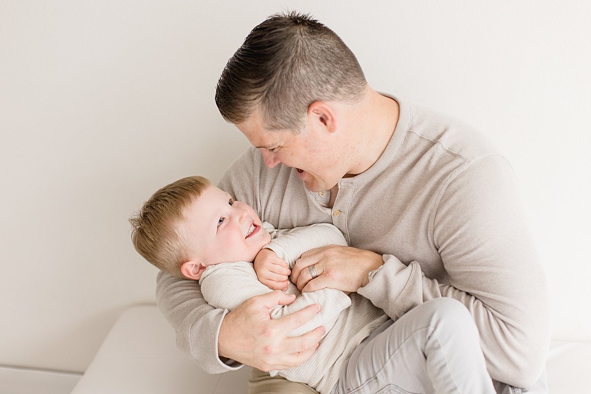 Dad tickling his young son during a milestone session with Ambre Williams Photography in Huntington Beach