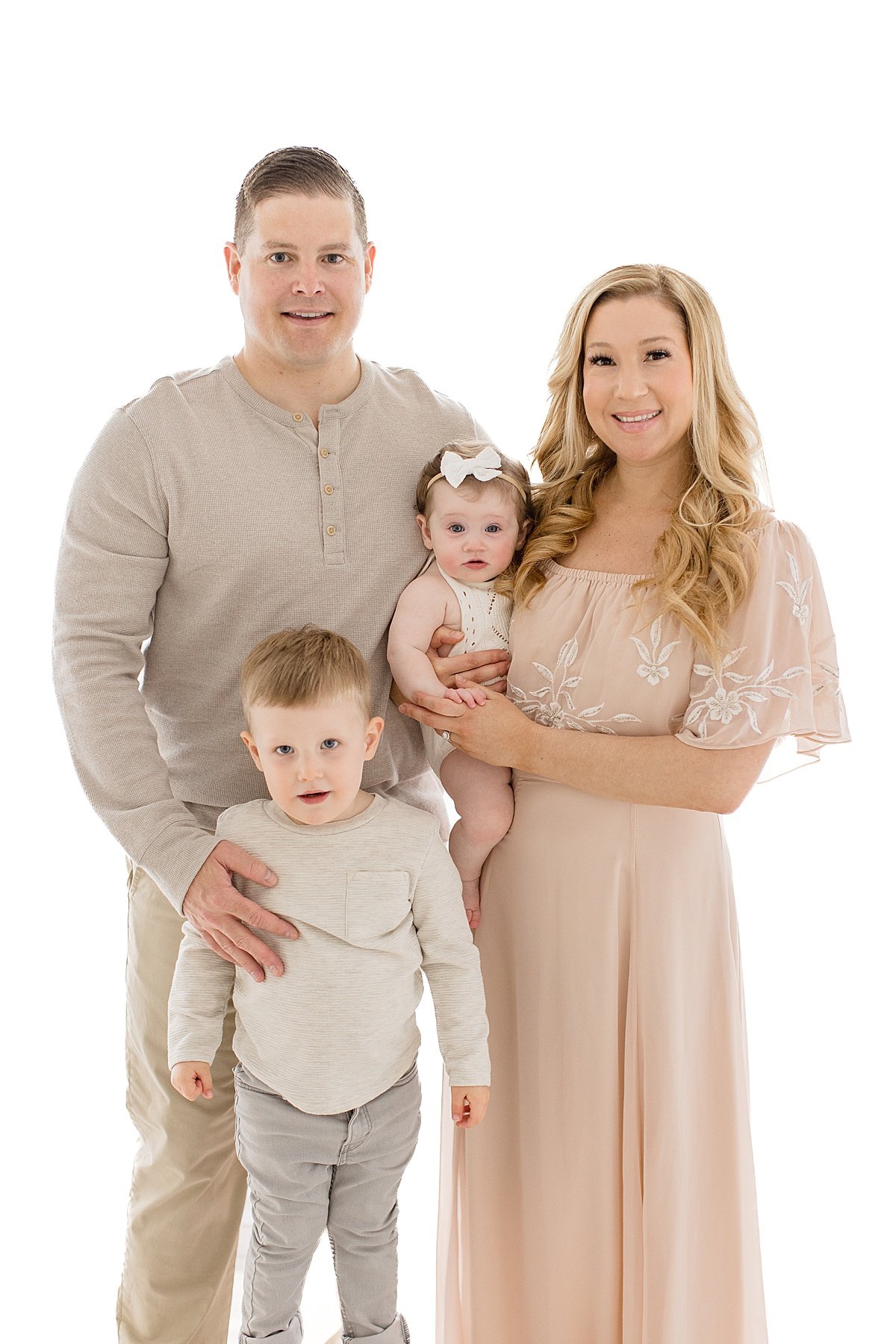 Family portrait with mom, dad, and two young children at Huntington Beach Portrait Session with Ambre Williams Photography