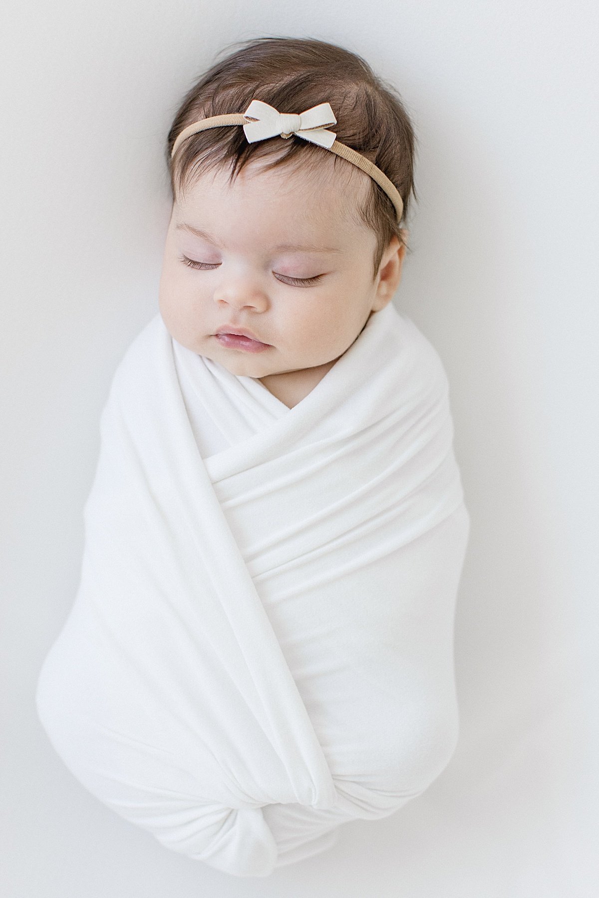 Newborn girl swaddled in blanket during portrait session with Ambre Williams Photography in Newport Beach 