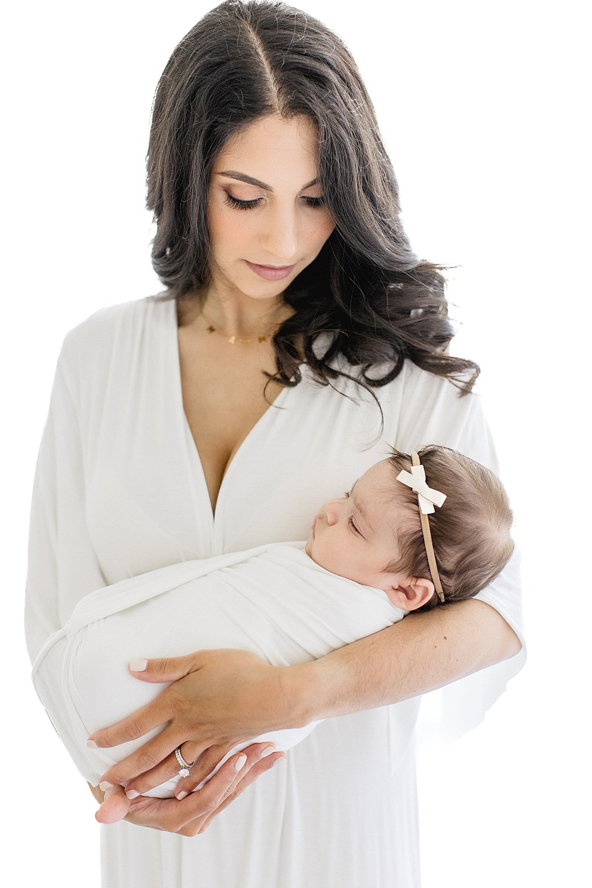 Mom holding newborn baby during portrait session in Newport Beach with Ambre Williams Photography
