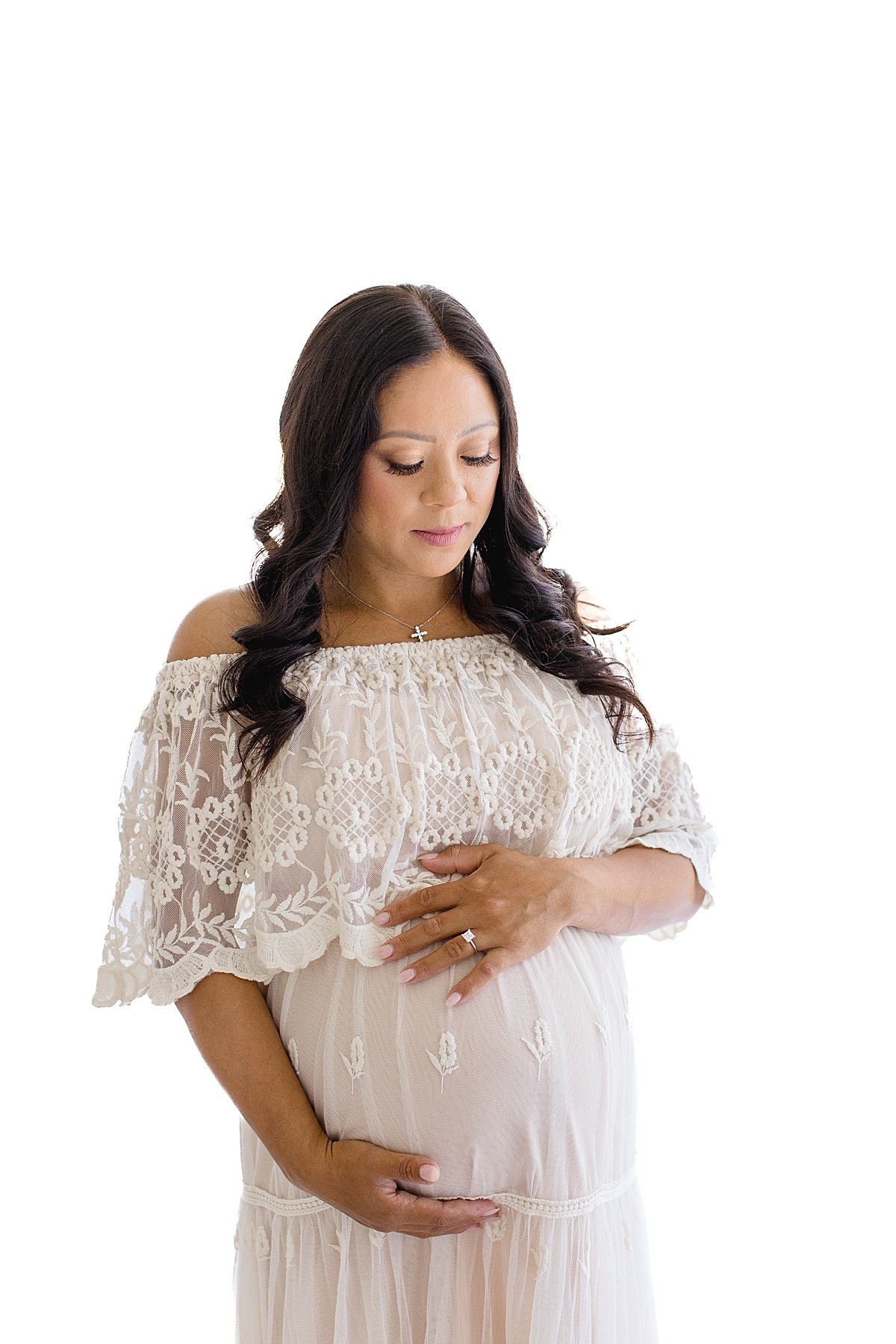 Mom looking at pregnant belly during studio session in Newport Beach | Ambre Williams Photography