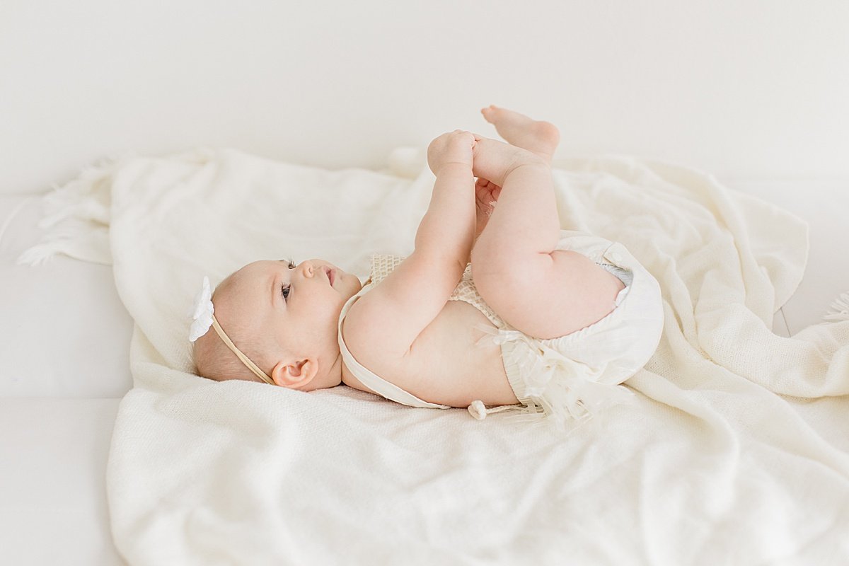 6Mon sitter photography session, baby girl holding feet with Ambre Williams Photography in OC