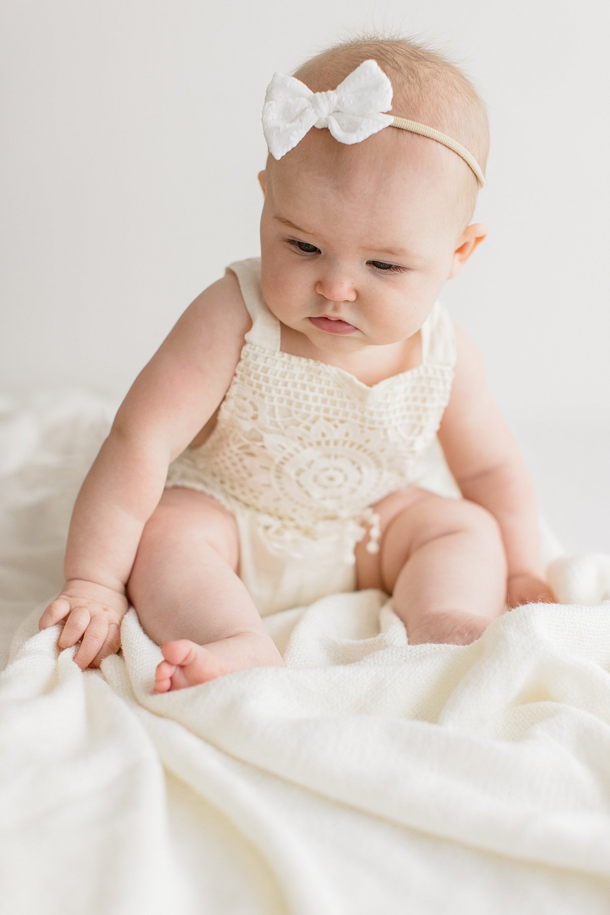 distracted baby during milestone session with Ambre Williams Photography in Newport Beach studio
