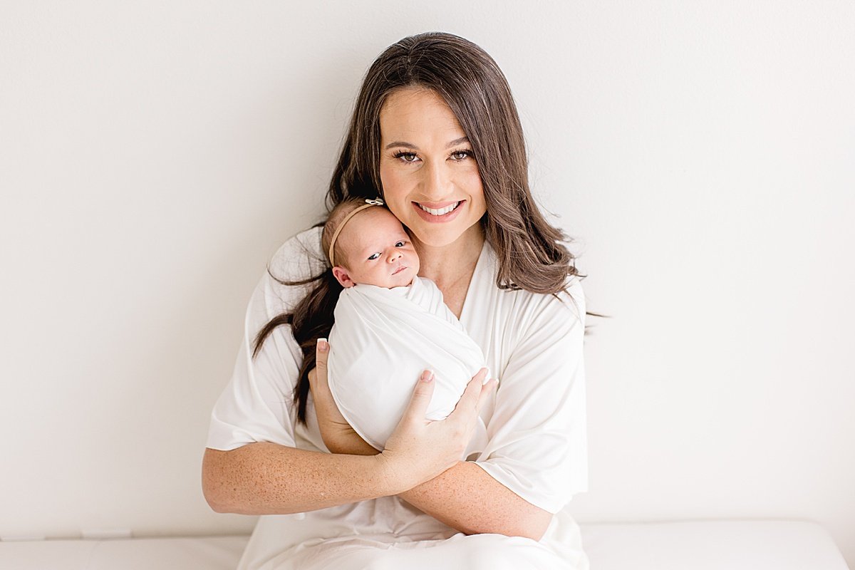 Ambre Williams photographs new mom holding baby daughter in her Newport Beach Photography Studio