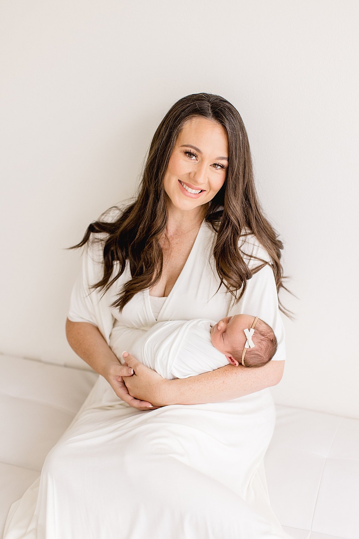 Happy mom holding her new daughter at Newborn Photography Session with Ambre Williams Photography