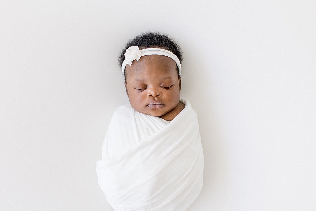 Beautiful Baby Girl daughter swaddled with a bow in studio for newborn portrait session | Ambre Williams Photography in California