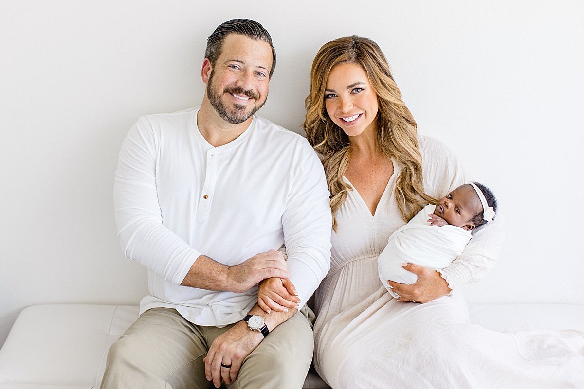 Mom and Dad smiling with their newborn baby | Ambre Williams Photography in Newport Beach