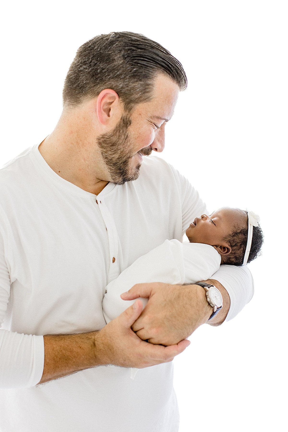 Dad holding newborn daughter during newborn session with Ambre Williams in Newport Beach California