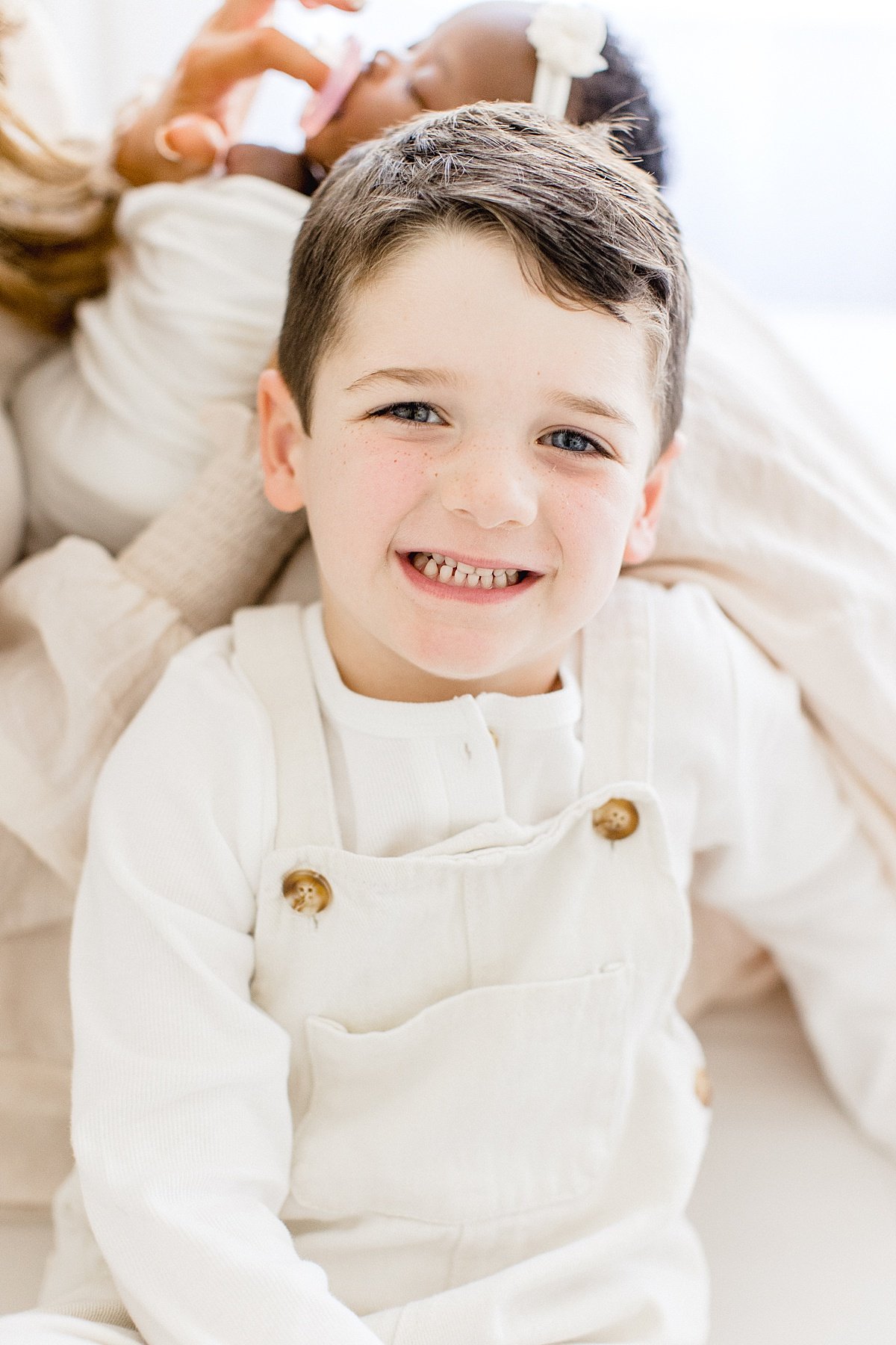 Big Brother smiling at camera during newborn studio session in Newport Beach with Ambre Williams