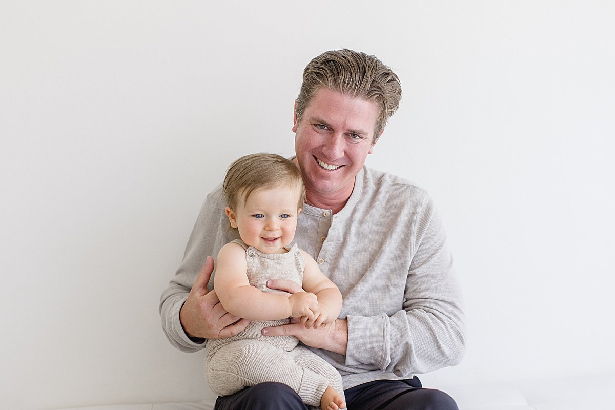 Smiling dad holding his son during milestone portrait session with Ambre Williams Photography in Newport Beach