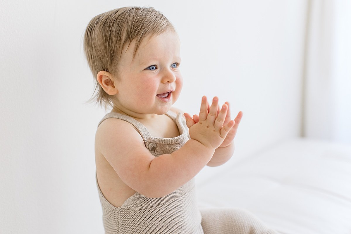 Clapping Happy Baby on his first birthday photography session in Newport Beach Studio with Ambre Williams