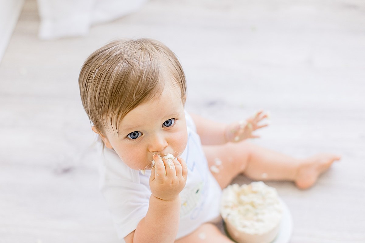 Baby eating smash cake during first birthday portrait session | Ambre Williams Photography in California