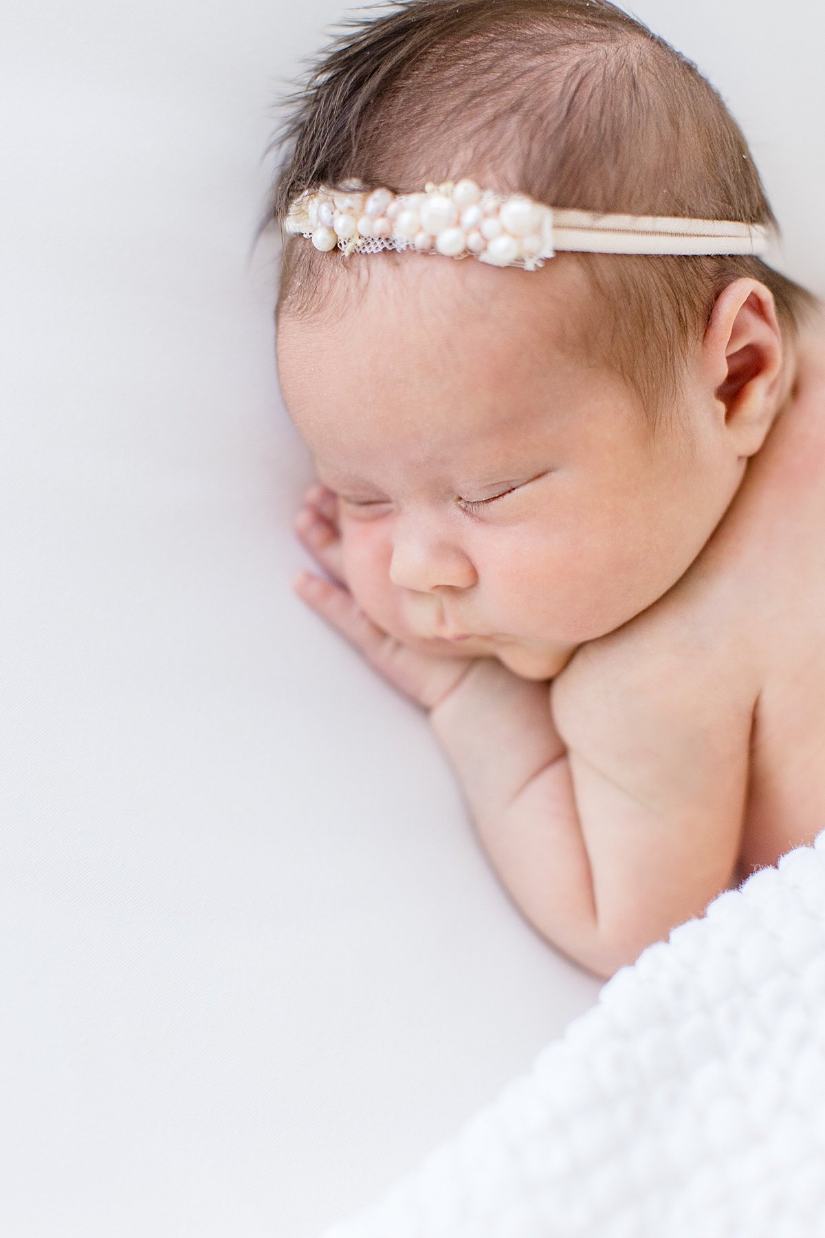 Sleepy little baby girl newborn wearing jeweled headband | Ambre Williams in Newport Beach California