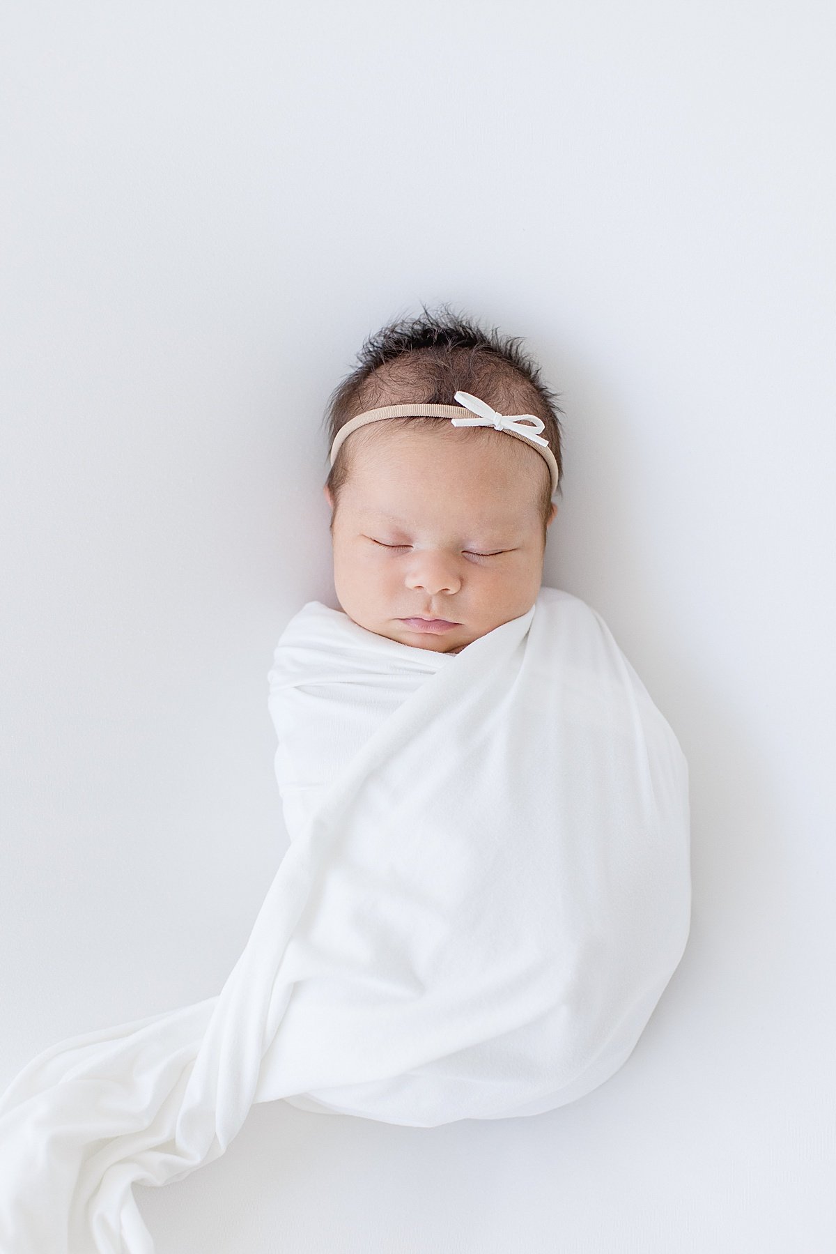 Sleepy newborn baby girl during portrait session with Ambre Williams in Newport Beach California