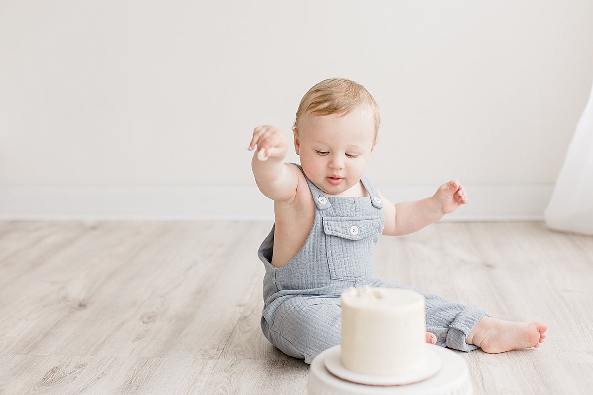 Ambre Williams Photographs little one-year old boy playing with smash cake in studio at Newport Beach, CA