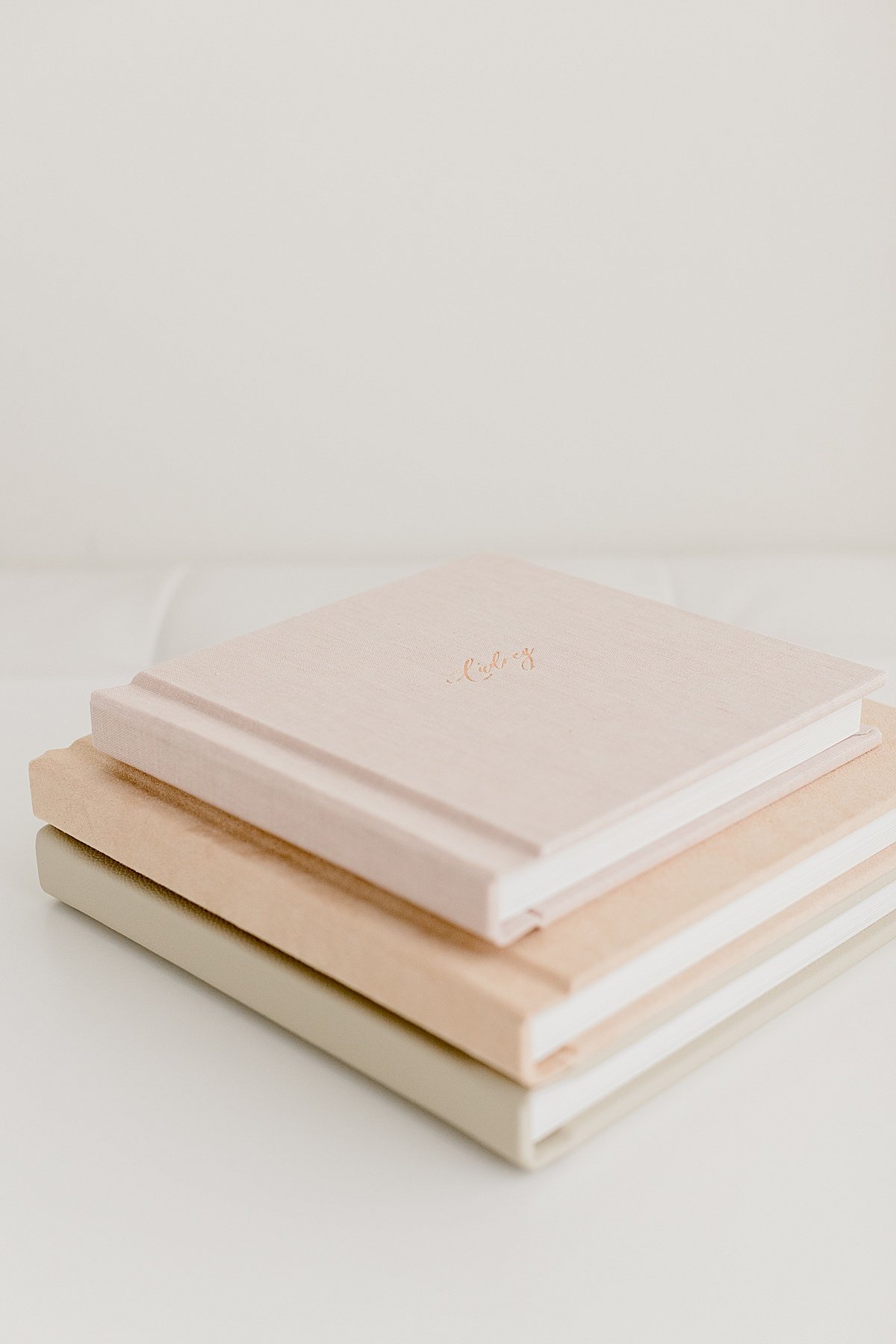 Stack of 3 muted color covered heirloom family photo album | Ambre Williams Photography in Newport Beach California