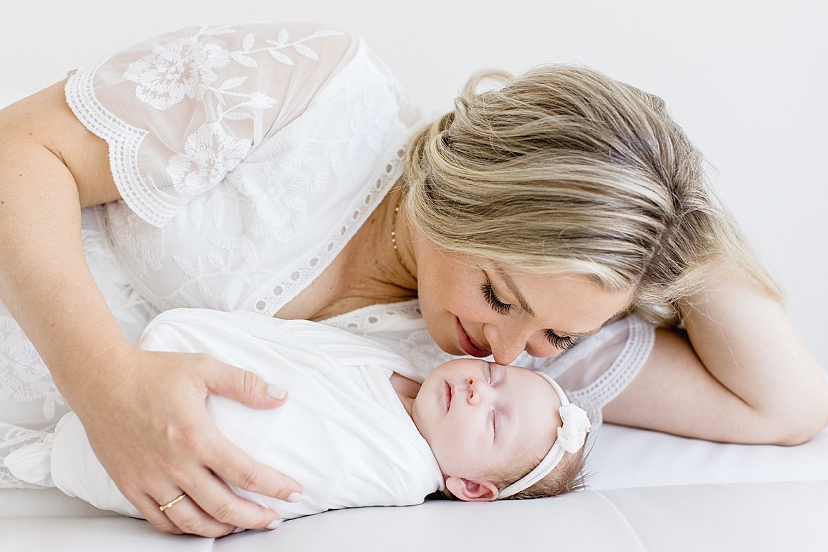 mom and baby laying down during newborn portrait session with Ambre Williams in her Newport Beach studio