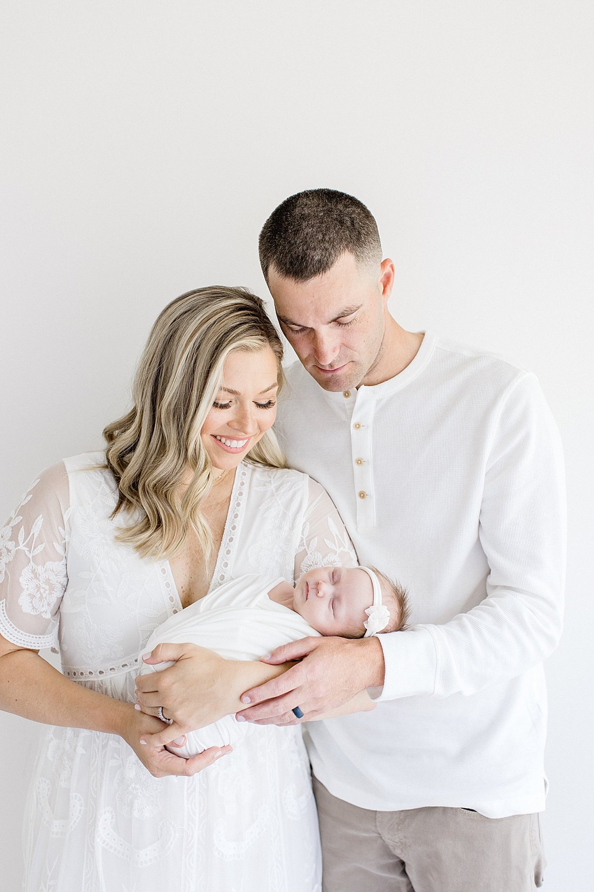Newport Beach Photographer Ambre WIlliams photographs mom, dad, and newborn baby girl during portrait session in studio