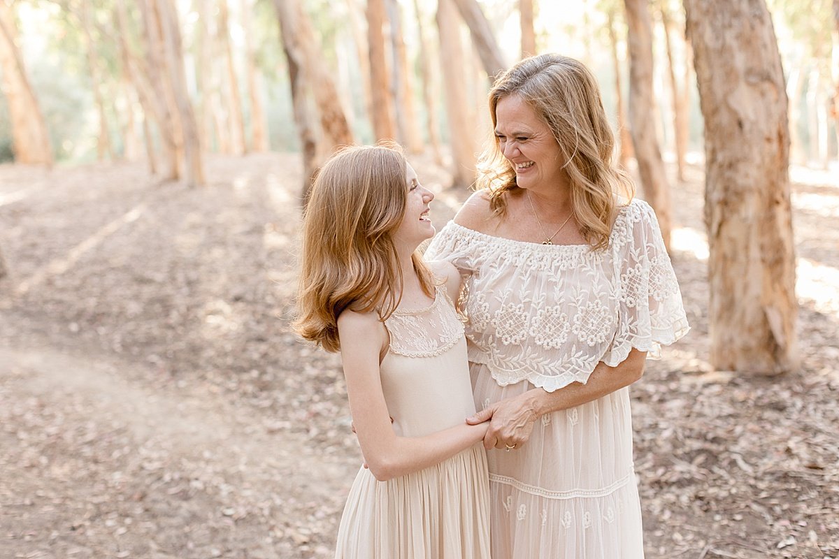 Mother and youngest daughter hug while on outdoor portrait session with Ambre Williams Photography