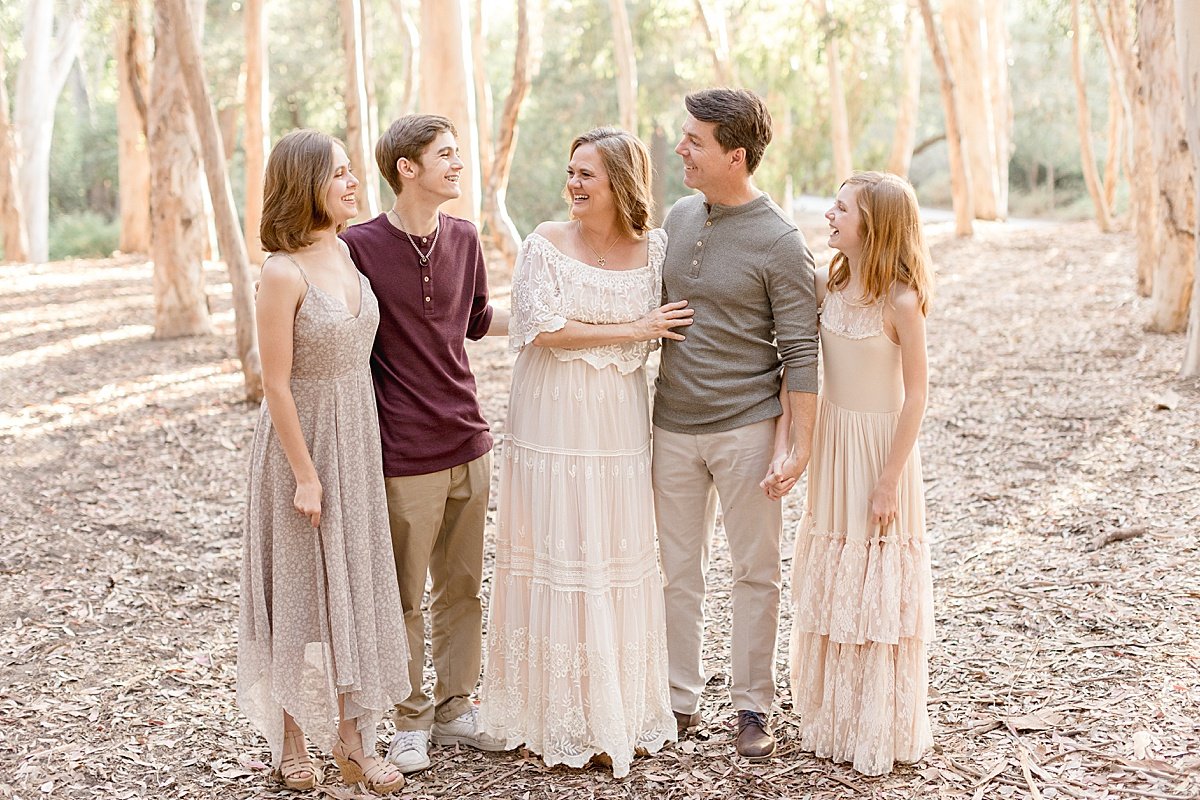 Mom and Dad with their three grown children during outdoor portrait session in woods with Ambre Williams Photography