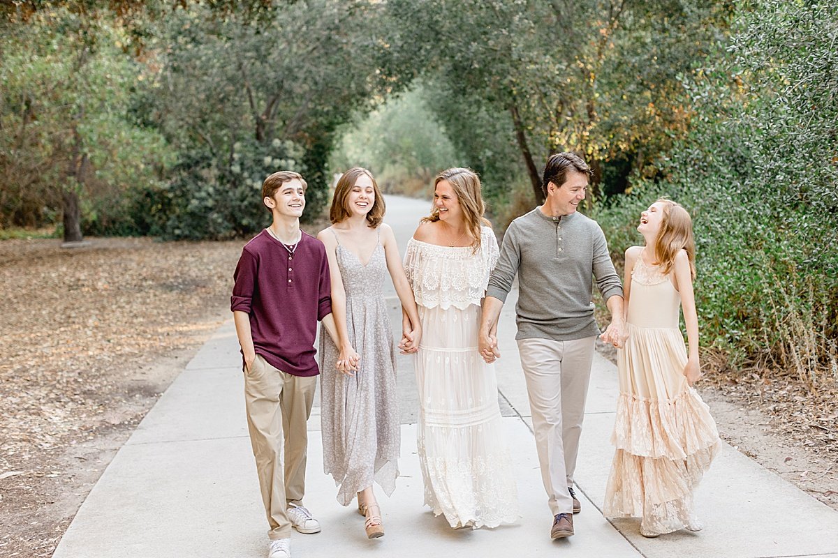 Family walking in the road laughing together during outdoor portrait session with Ambre Williams Photography