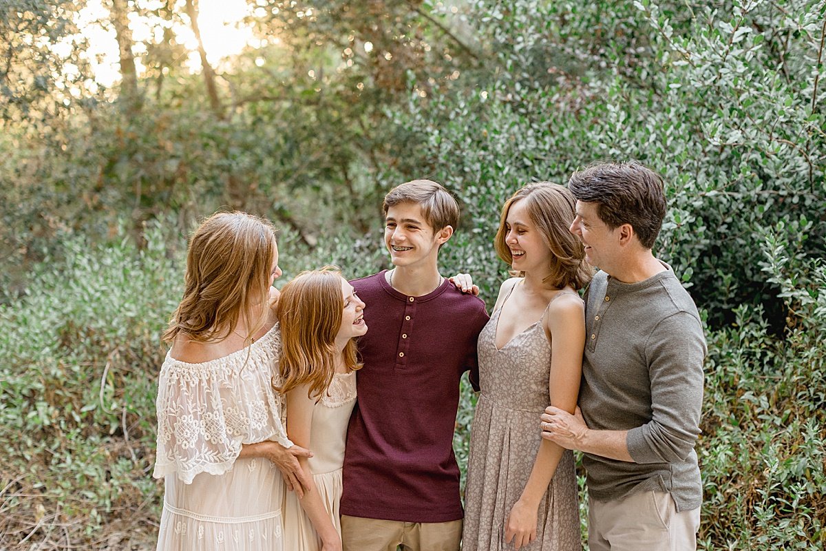 Family laughing together in forest with Ambre Williams Photography in Newport Beach California