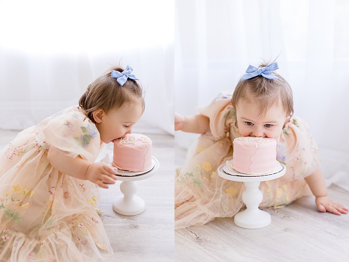 Silly one year old baby eating cake during portrait session smash cake with Ambre Williams Photography