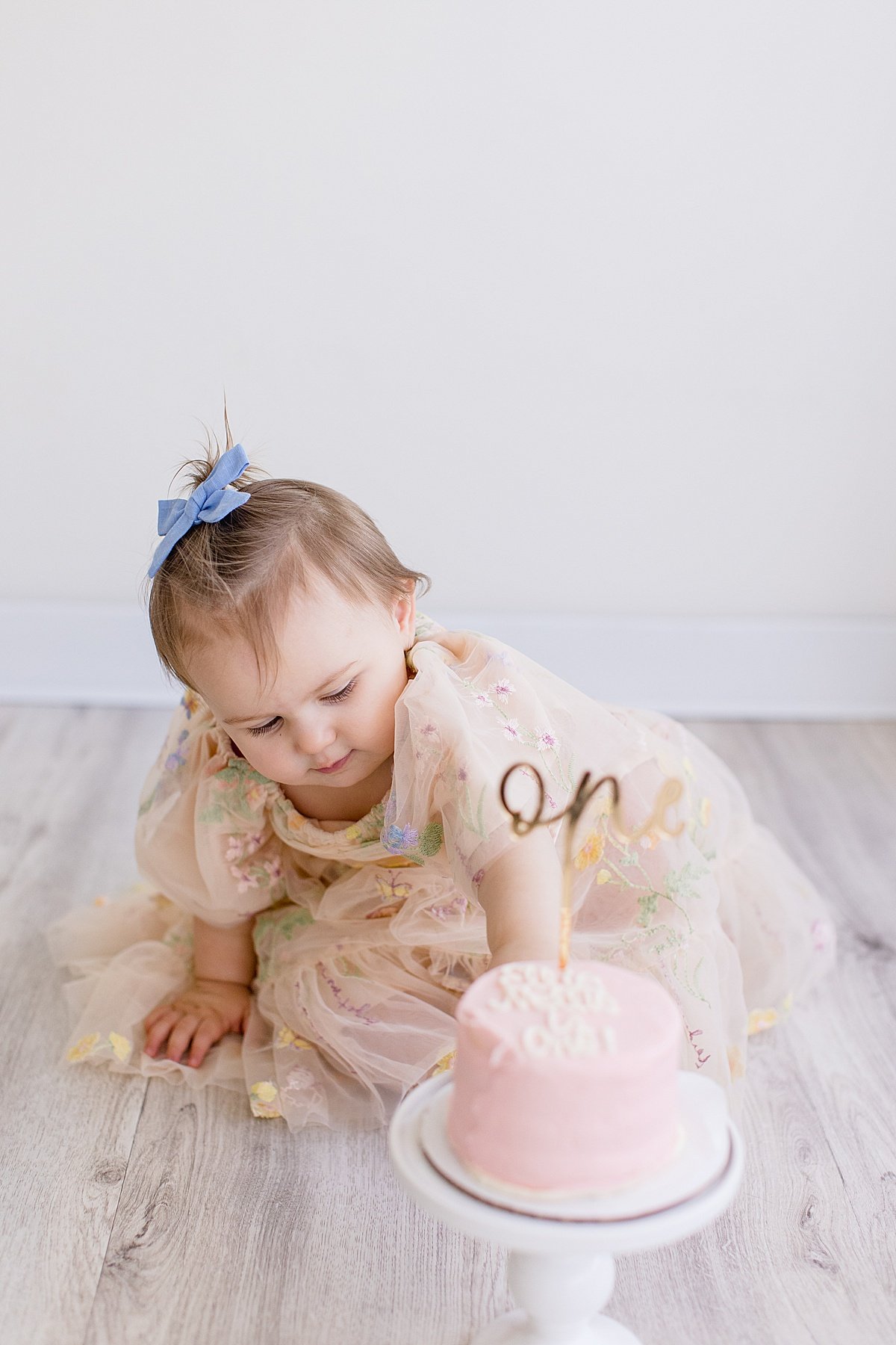 One year old daughter smash cake during studio session with Ambre Williams Photography in Newport Beach California