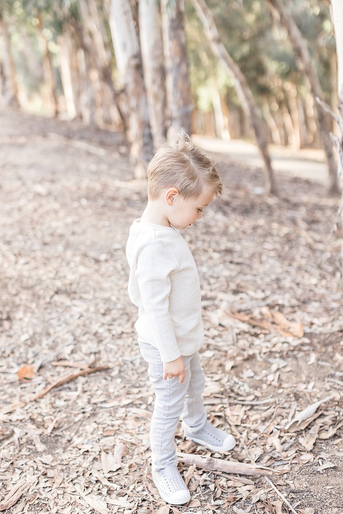 Candid photo of son playing in the forest in Newport Beach California with Ambre Williams Photography