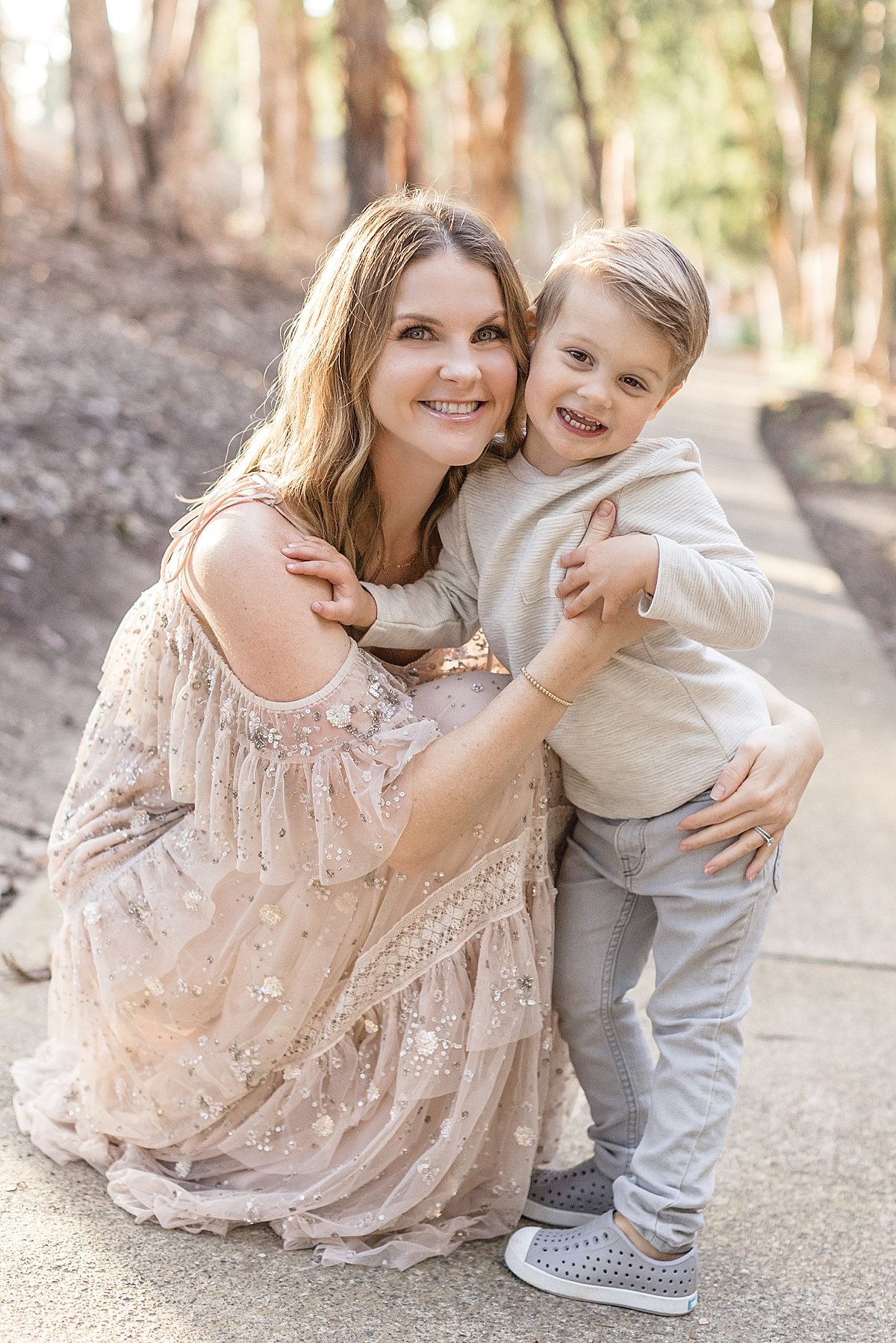 Happy candid portrait of mom and son during outdoor fall session with Ambre Williams Photography in Newport Beach