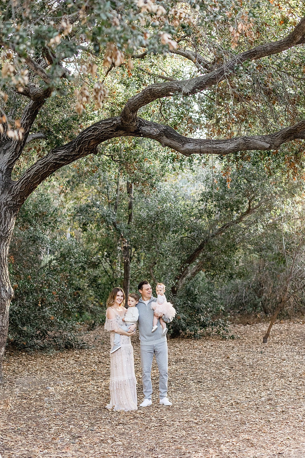 happy family smiling in lake forest in California with Ambre Williams Photography