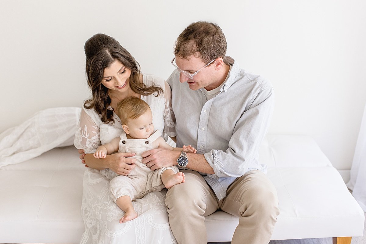 Mom and dad holding baby son during portrait session with Ambre Williams Photography in Newport Beach