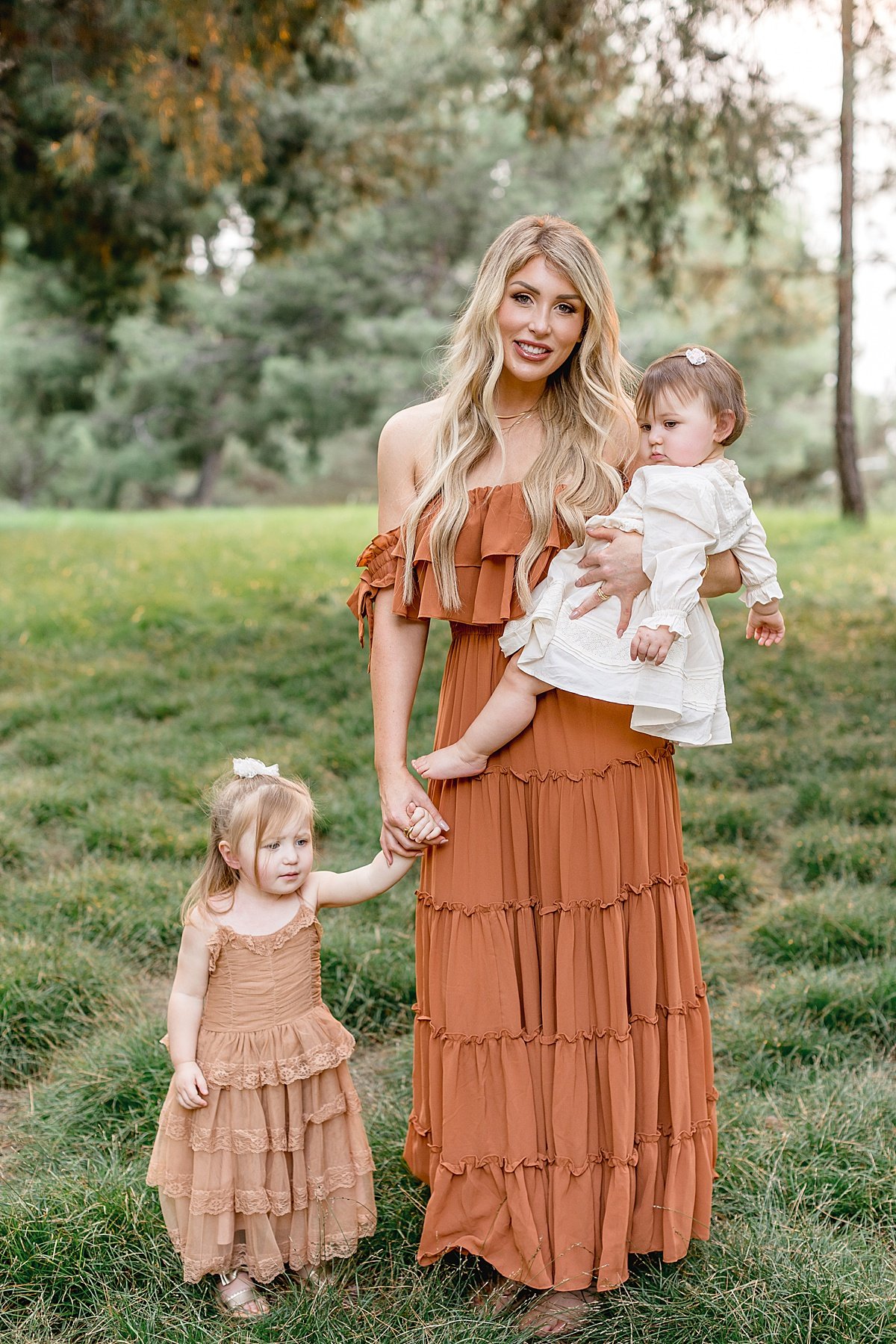 Beautiful mom with two daughters in Lake Forest California in Newport Beach. Fall portrait session with orange and autumn color dresses