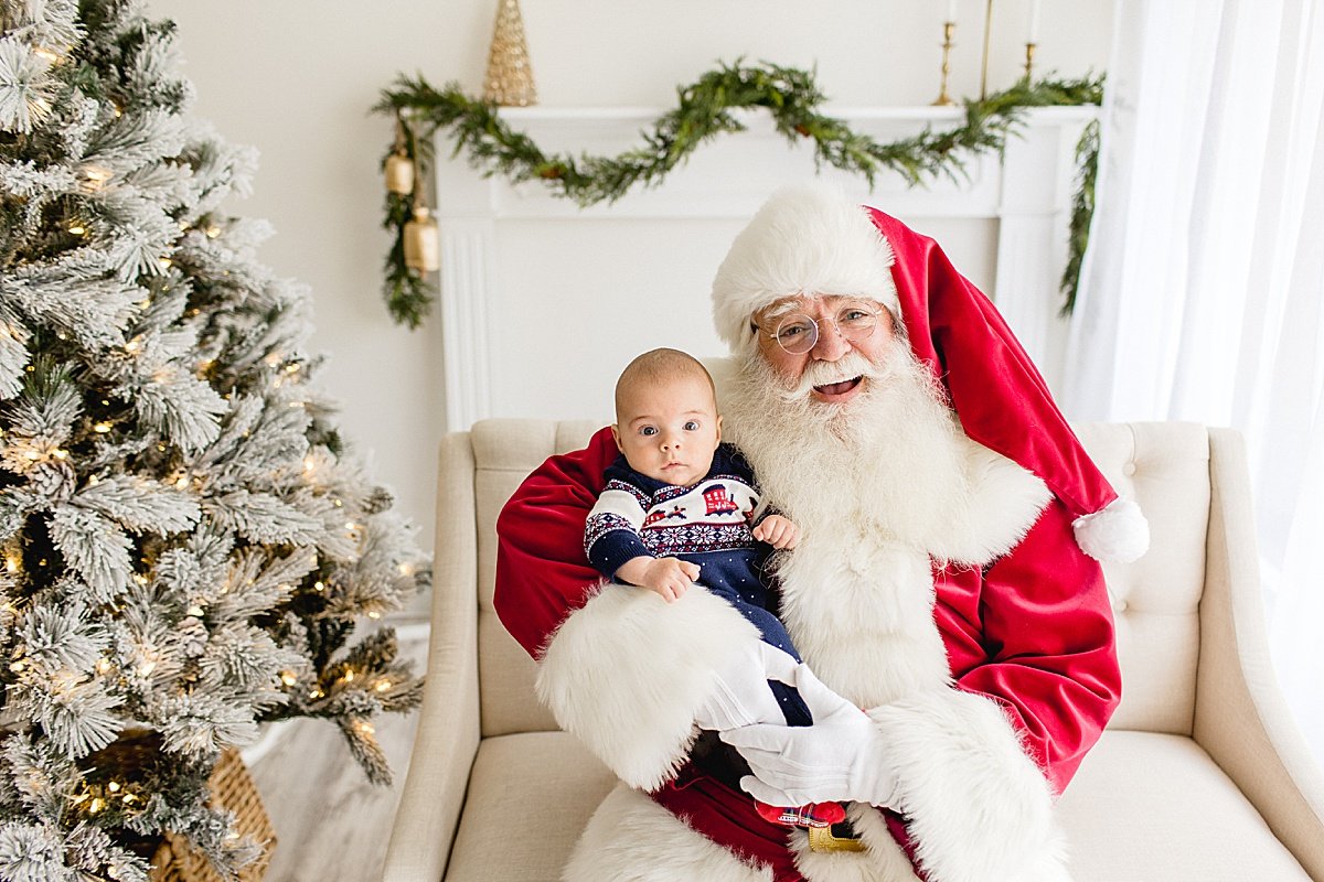 Santa smiling with Baby during Santa's Magical Experience with Ambre Williams Photography in Newport Beach studio