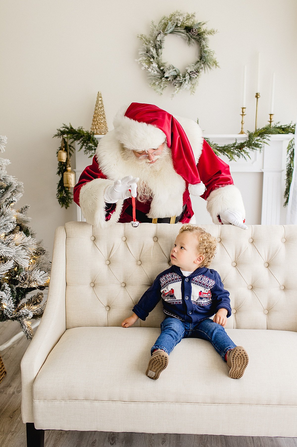 Santa sneaking up on child during Santa's Magical Experience in Newport Beach studio with Ambre Williams Photography