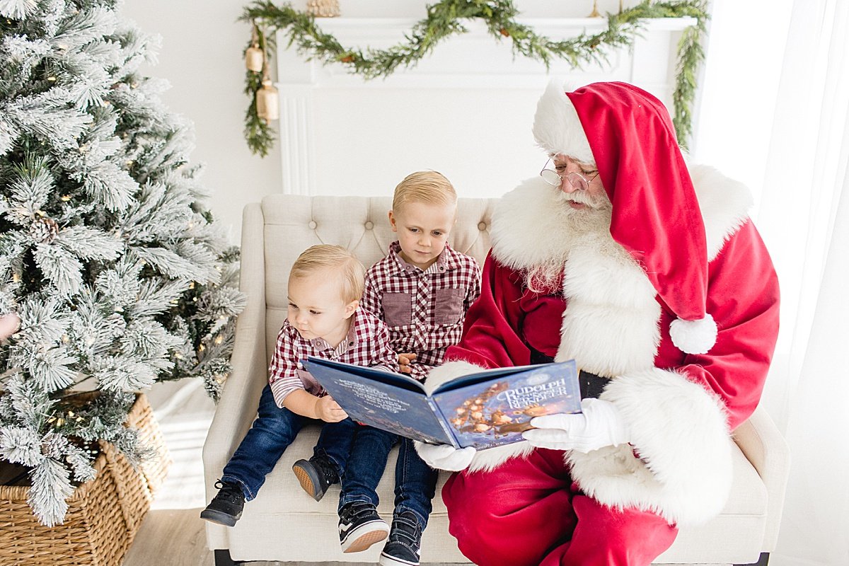 Santa reading two young boys a holiday Christmas story with Santa's Magical Experience with Ambre Williams Photography in Newport Beach studio